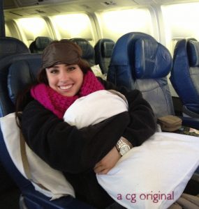 Chelsey with an eye mask and pillow waking up on a flight from Paris to Chicago.